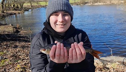 Stolze Anglerin mit ihrem frisch gefangenen Fisch